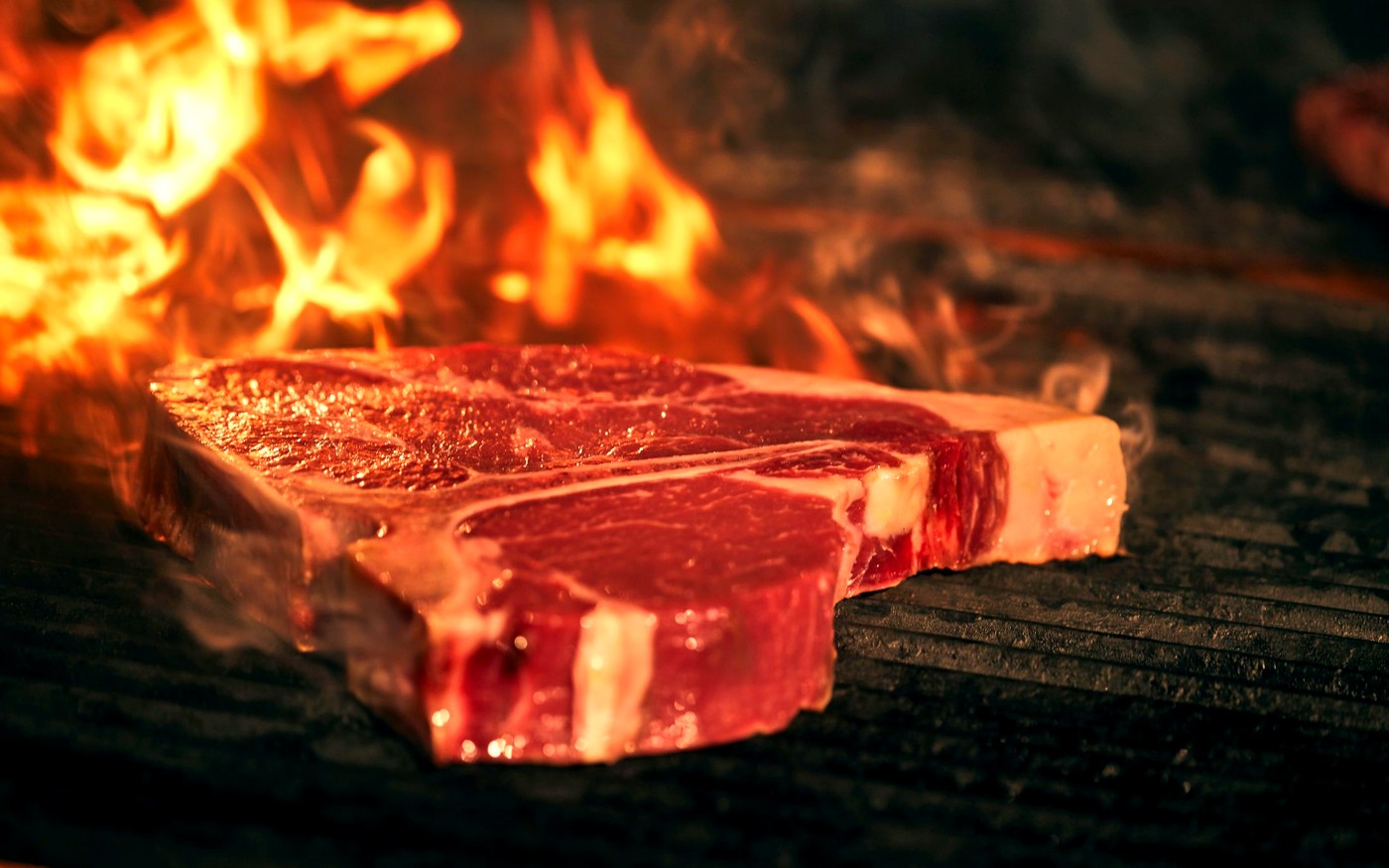 T-bone steak searing over open flames