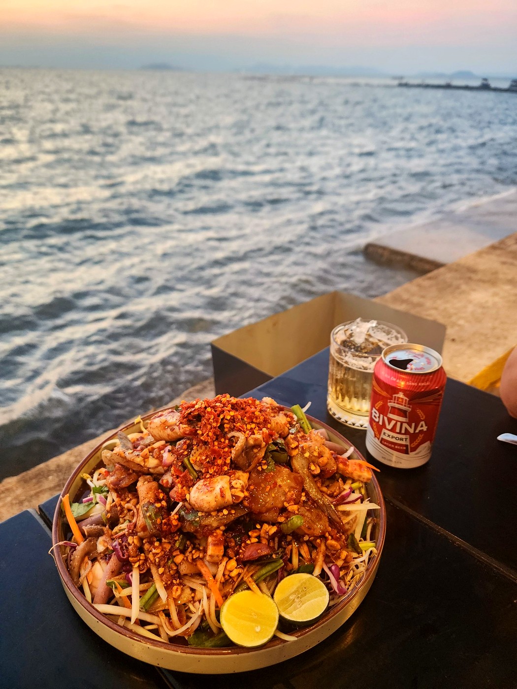 Spicy seafood salad served by the sea at sunset